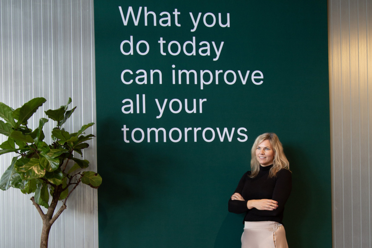 Vibeke Trærup - Marketing manager at Deif in front of improve tomorrow sign